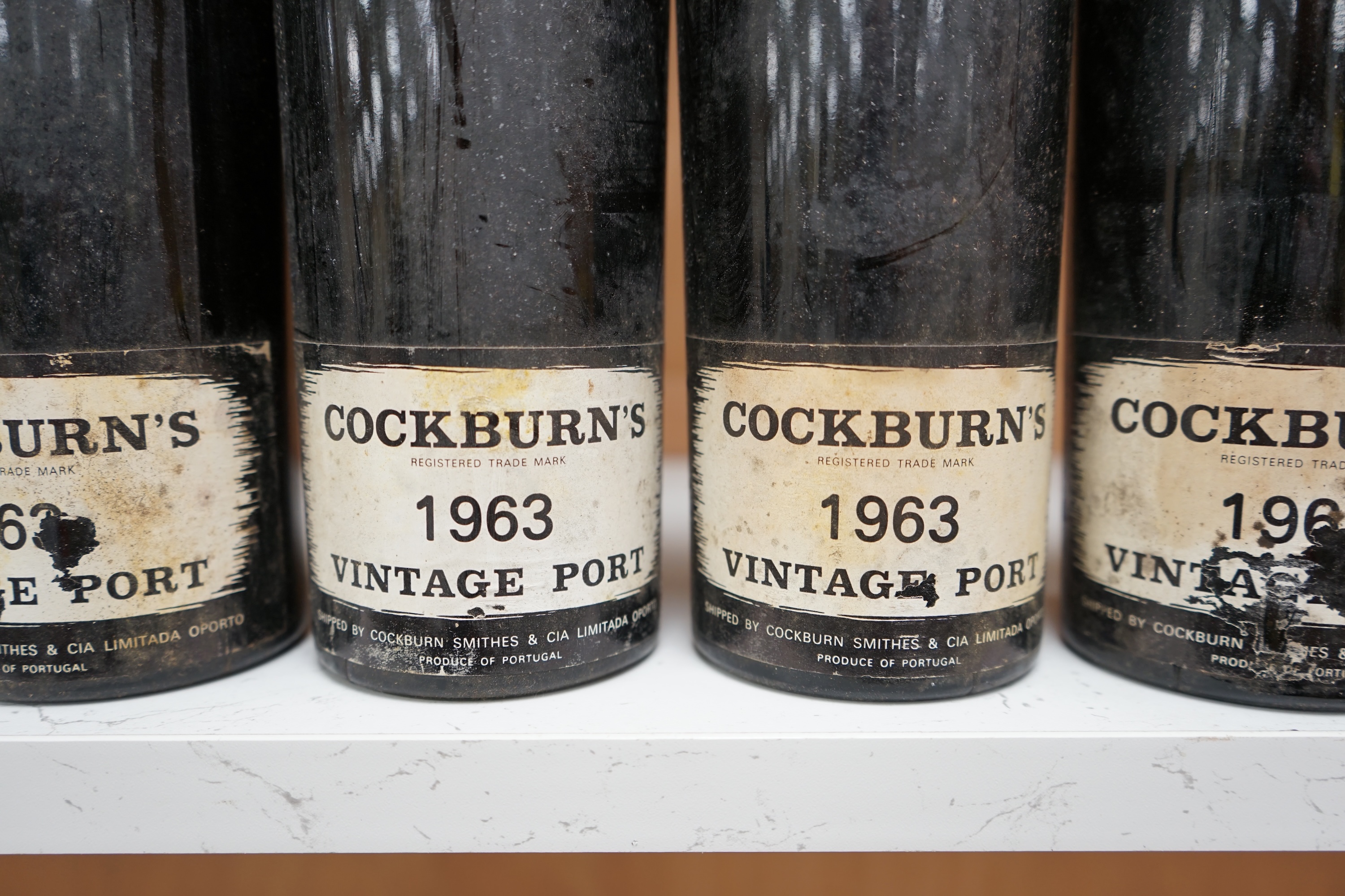 Four bottles of Cockburn’s 1963 vintage port. Condition fair, some wear to labels.